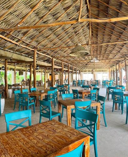 a restaurant with wooden tables and blue chairs at Hotel Arena Beach Cartagena in Cartagena de Indias