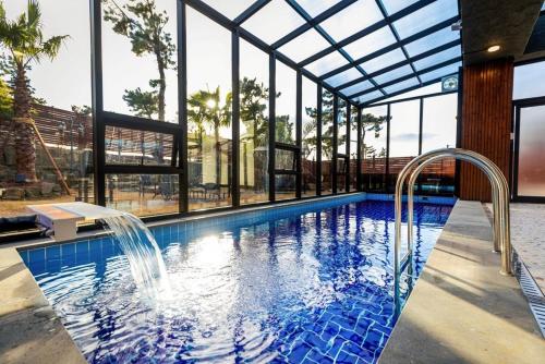 a swimming pool with water fountains in a building at Jeju Mare Private Pool Villa in Jeju