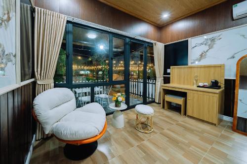 a room with two chairs and a desk and a window at Tsunami bungalow in Cat Ba