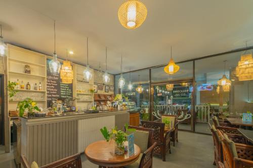 a restaurant with tables and chairs and a bar at Nirmala Hotel Jimbaran in Jimbaran