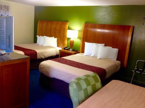 um quarto de hotel com duas camas e uma televisão em Pilgrim Inn & Cottages em Plymouth
