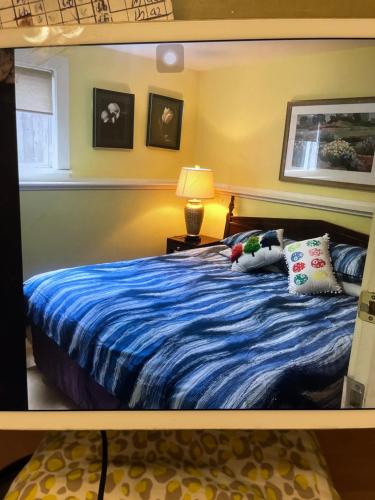 a bedroom with a blue bed with pillows and a lamp at Linda guesthouse in Vancouver