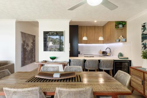 a kitchen and dining room with a wooden table and chairs at Little Cove Currumbin in Gold Coast