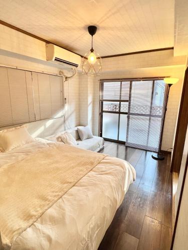 a bedroom with a large bed and a chandelier at ペットと泊まれる Tatami & B 池上 202 2DK 40m2 in Tokyo