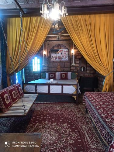ein Schlafzimmer mit Bett und Vorhängen in einem Zimmer in der Unterkunft The Shangri-La heritage Haveli BNB in Jodhpur