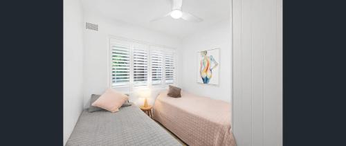 a bedroom with a bed and a window at Beachfront Getaway in Sydney