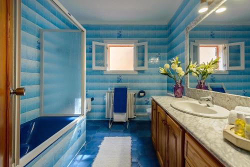 ein blaues Badezimmer mit Waschbecken und Badewanne in der Unterkunft Delightful Ibiza Villa Spectacular Mountain Views Villa Jasmine in Sant Rafael de Sa Creu