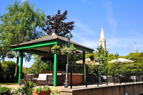 a gazebo with tables and chairs in a park at Norfolk Royale Hotel in Bournemouth
