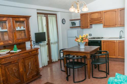 a kitchen with a table and chairs and a kitchen with a sink at Agriturismo Il Casale di Monica in Rivotorto 