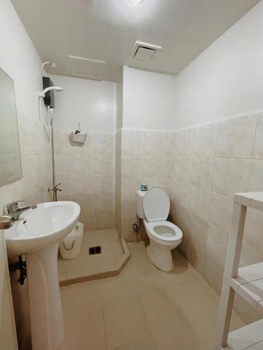 a bathroom with a toilet and a sink at Cozy 2BR Condo Near Davao Airport with Samal View in Davao City