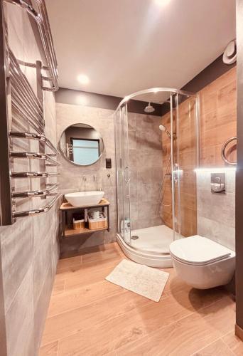 a bathroom with a shower and a toilet and a sink at Valmiera Stay Apartment in Valmiera