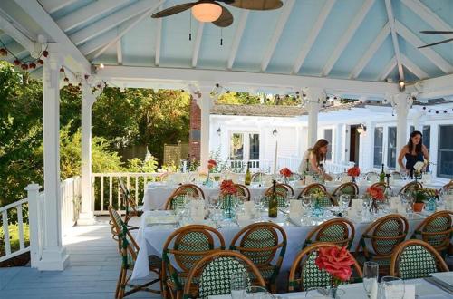 a long table with white tables and chairs under a white canopy at Shelter Island House in Shelter Island Heights