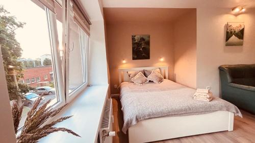 a small bedroom with a bed and a window at Valmiera Stay Apartment in Valmiera