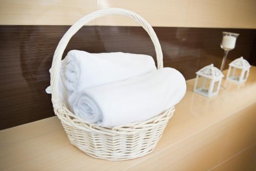 een rieten mand op een aanrecht met handdoeken bij Hotel Hibiskus in Boguchwała