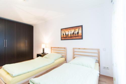 ein Schlafzimmer mit 2 Betten und einem Wandgemälde in der Unterkunft Ferienwohnung Neuss in Neuss