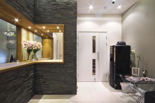 a room with a refrigerator and a brick wall at Queens Hotel in London