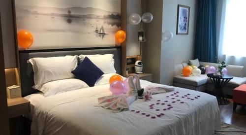 a bedroom with a white bed with balloons on it at East Queen Hotel (Xi'an Beimen Metro Station) in Xi'an