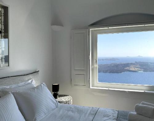 a bedroom with a bed and a large window at Premium Santorini Villa Villa Campbell 1 Bedroom Spectacular Aegean Sea Views Private Outdoor Hot Tub Imerovigli in Imerovigli