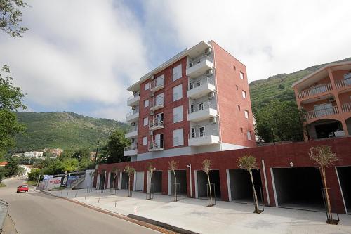 un edificio in mattoni rossi su una strada alberata di Apartments Residence Dj a Petrovac na Moru