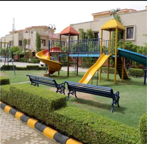 un parque con parque infantil con toboganes y bancos en Madhav Mohini Kunj -2 BHK Near Prem Mandir, en Vrindāvan