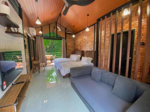 a bedroom with a couch and a bed in a room at Casa Damai Janda Baik - RIVERVIEW TINY HOUSE in Bentong