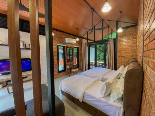 彭亨Casa Damai Janda Baik - RIVERVIEW TINY HOUSE的卧室设有一张砖墙内的大床
