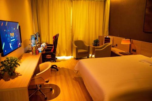a hotel room with a bed and a desk at IU Hotel Zhangye High-Speed Railway Station in Zhangye