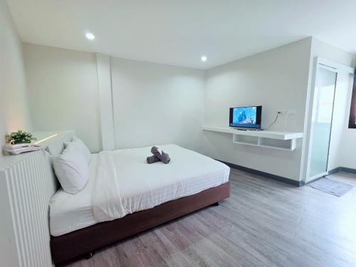 a bedroom with a bed with a teddy bear on it at Ma Non Nont Hotel & Apartment in Nonthaburi