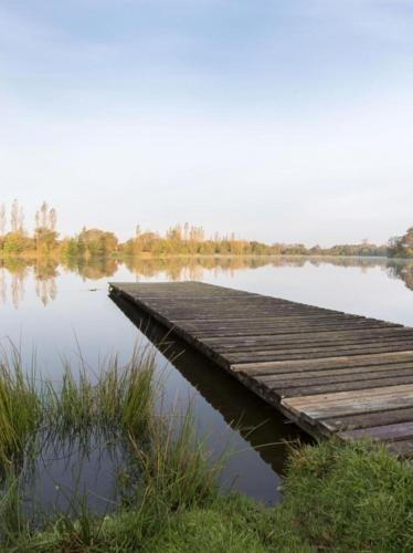 a wooden dock in the middle of a lake at La cle des champs in Langonnet