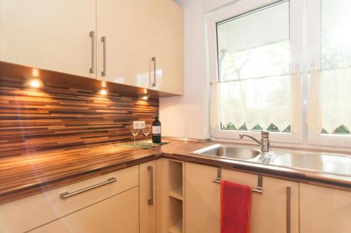 eine Küche mit einem Waschbecken und einem Fenster in der Unterkunft Ferienwohnung Neuss in Neuss