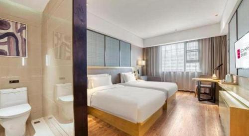 a hotel room with a white bed and a sink at Echarm Hotel Jingjiang Bus Passenger Station Fanggu Street in Jingjiang