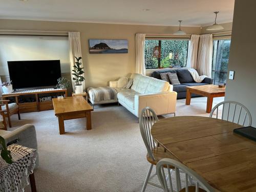 a living room with a couch and a tv at Mount Maunganui House -Walk to Beach, Shops, Cafés in Mount Maunganui