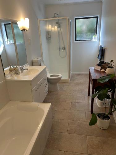 a bathroom with a tub and a sink and a toilet at Mount Maunganui House -Walk to Beach, Shops, Cafés in Mount Maunganui