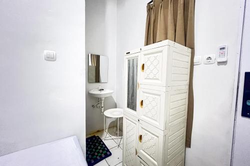 a bathroom with a white cabinet and a sink at Guest House 21 RedPartner in Jakarta