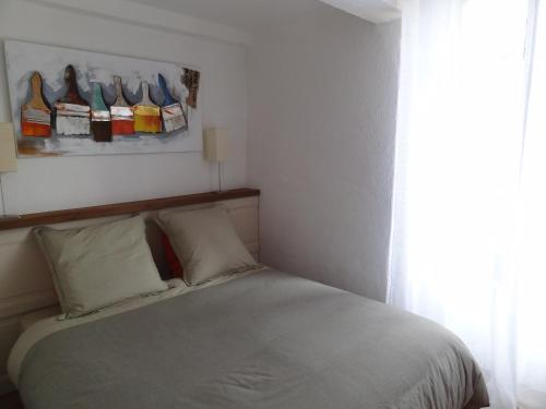 カマレにあるLes Hauts de Camarèsのベッドルーム1室(ベッド1台付)、壁に靴を敷いた窓が備わります。