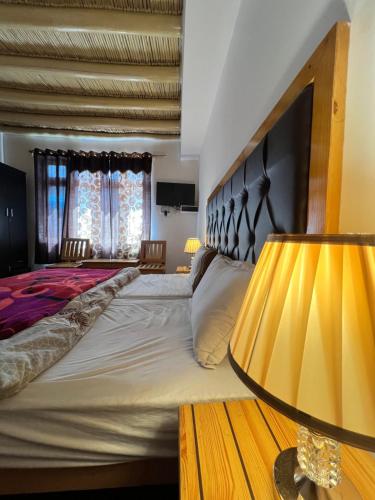 a bedroom with a large bed and a lamp at Sky Land guest house in Leh