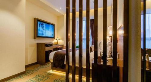 a hotel room with a bed and a television at James Joyce Coffetel· Xianyang Renmin Road Central Square Store in Xianyang
