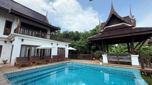 a swimming pool in front of a villa at CM8 Beds & Private Pool in Mae Pim