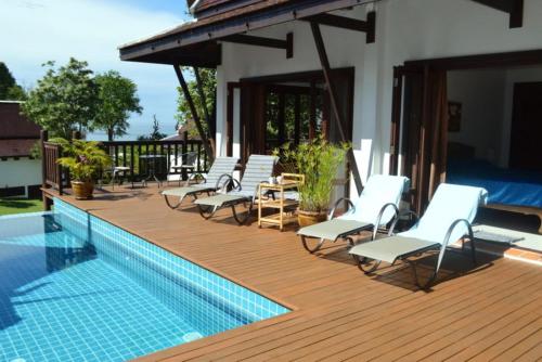 a group of chairs sitting on a deck next to a pool at CM8 Beds & Private Pool in Mae Pim