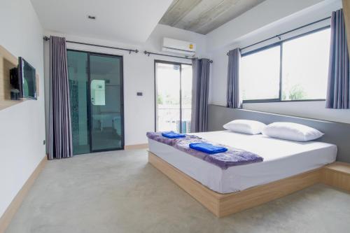 a bedroom with a bed with pillows and windows at Bed-room at Suvarnabhumi Airport -SHA- in Lat Krabang