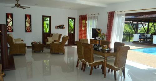 a dining room and living room with a table and chairs at CM8 Beds & Private Pool in Mae Pim