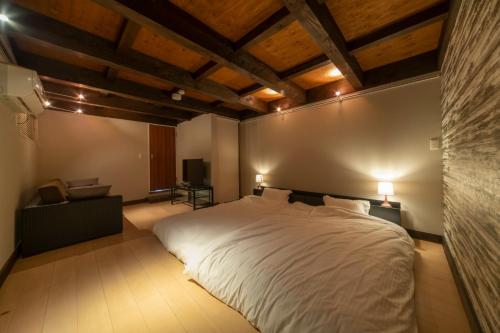 a bedroom with a large white bed and wooden ceilings at villa-rizo - Vacation STAY 13184 in Hida