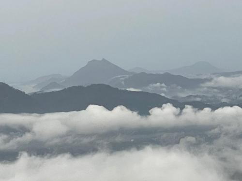 a view of clouds and mountains from an airplane at Peacock Hill Glamp in Gampola