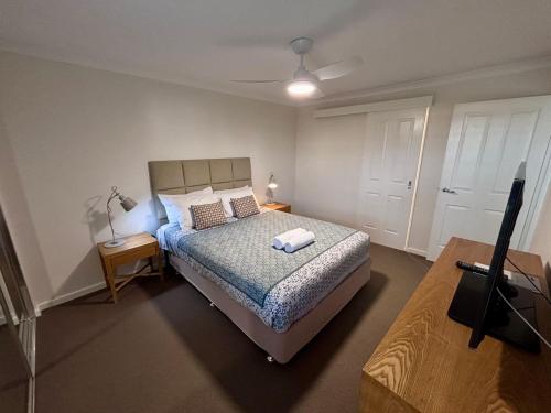 a bedroom with a bed and a tv in it at Escape to 67 at Cape View in Broadwater