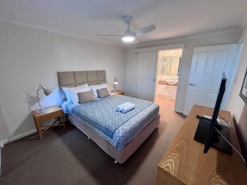 a bedroom with a bed and a flat screen tv at Escape to 67 at Cape View in Broadwater