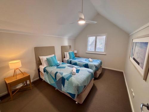 a bedroom with two beds and a window at Escape to 67 at Cape View in Broadwater