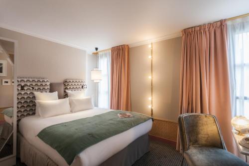 um quarto de hotel com uma cama e uma cadeira em Handsome Hotel em Paris