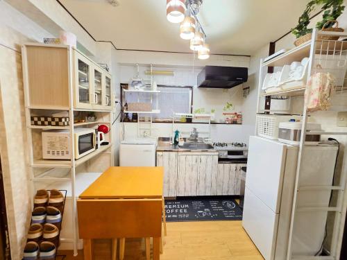 a kitchen with a white refrigerator and a wooden table at 302Near Ueno Heart of city in Tokyo