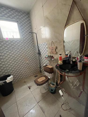 ein Badezimmer mit Toilette, Waschbecken und Spiegel in der Unterkunft Casa com 3 quartos in Belém
