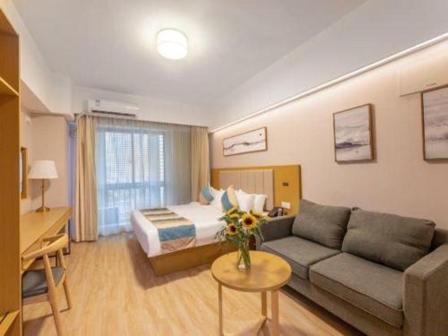 a hotel room with a couch and a bed at VX Hotel Wuxi Xinwu District Executive Center Wanda Plaza in Wuxi
